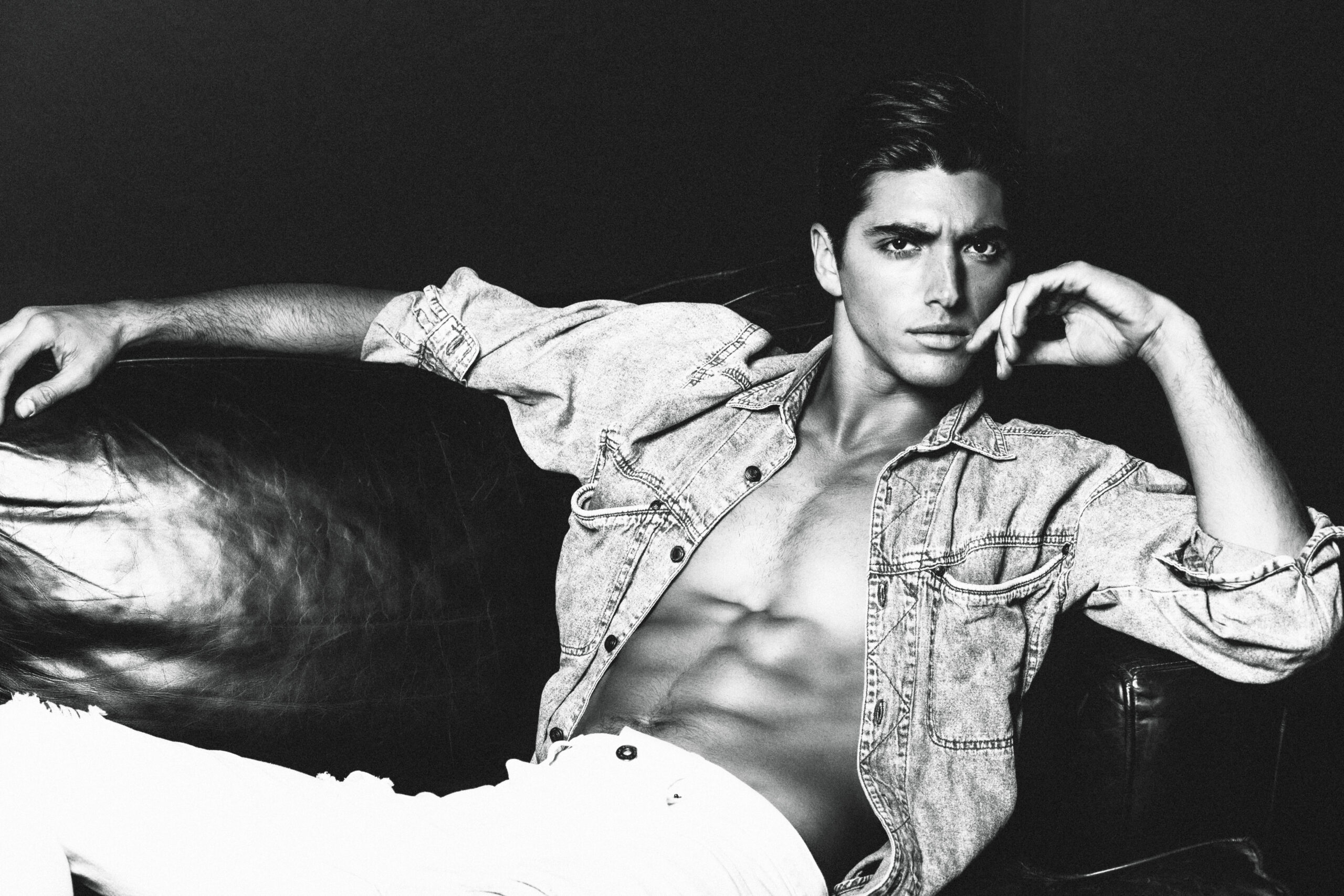 Taylor Zakhar Perez by Walid Azami, laying on a leather couch